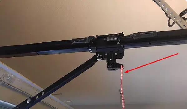 Close-up of a garage door opener trolley carriage with the red safety release rope removed